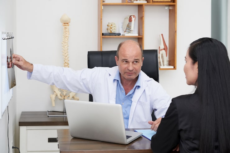 rear-view-patient-physiotherapist-s-consulted-by-professional-doctor_1098-18682
